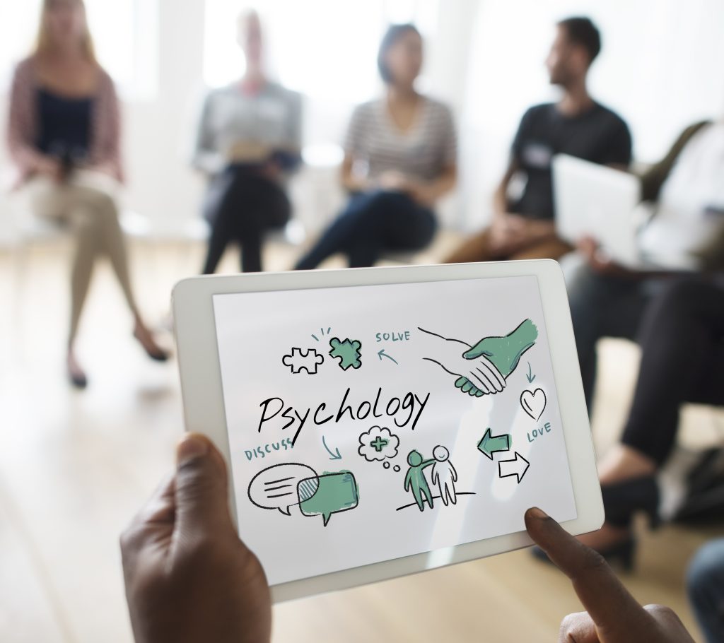 A group of colleagues engaging in a discussion about workplace situations impacting mental health, sharing experiences and support 